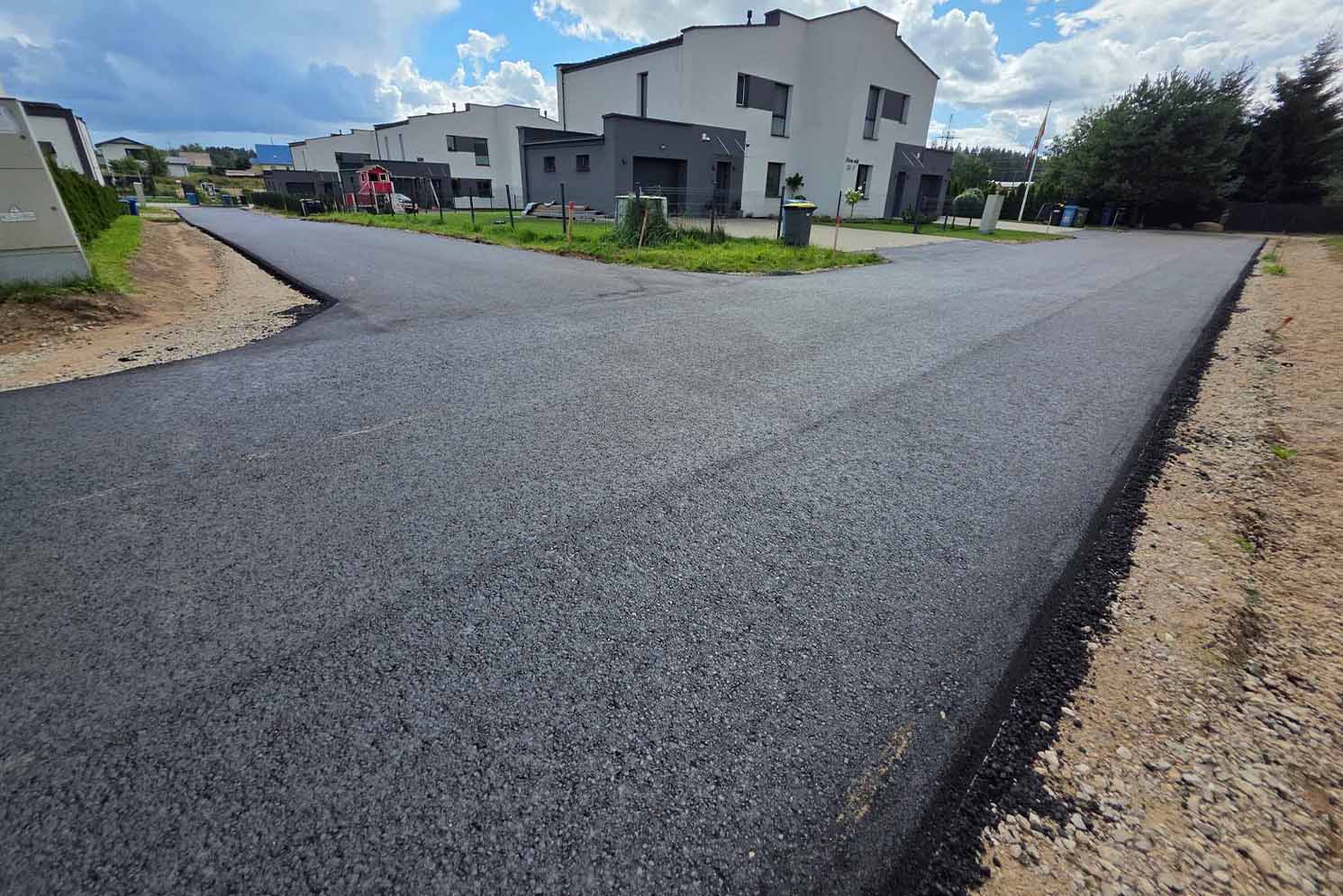 Asfaltuota gatvė gyvenamųjų namų kvartale